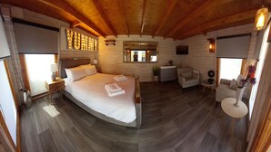 A cozy room with a large bed, wooden ceiling, and a mirror. - Sandy Toes Accommodation (Par)