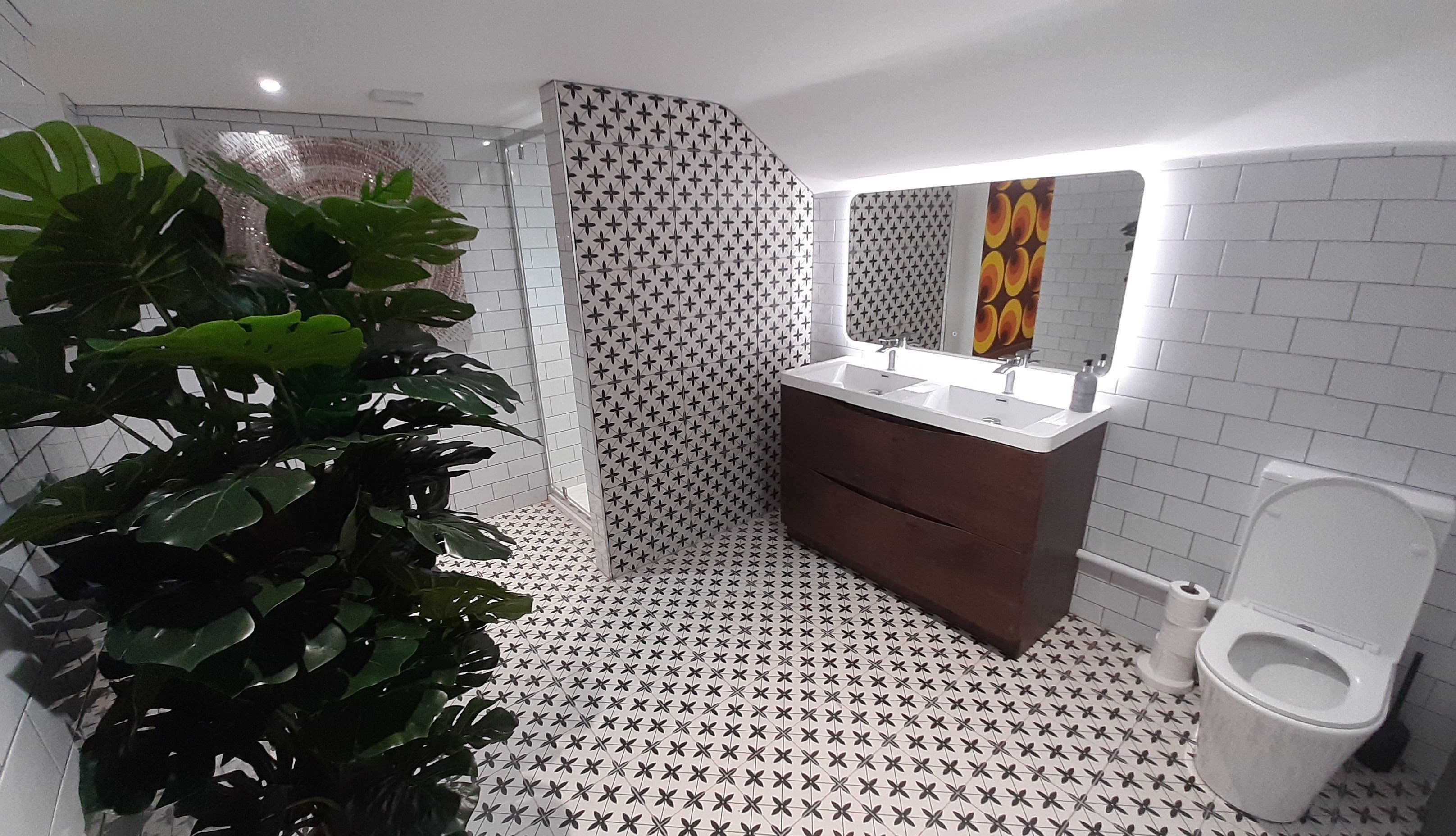 Un baño moderno con ducha, lavamanos e inodoro.