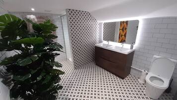 Une salle de bain moderne équipée d’une douche, d’un lavabo et de toilettes.