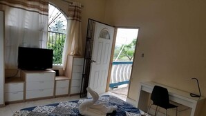 Une chambre à coucher avec un lit, une télévision, un bureau et une chaise.