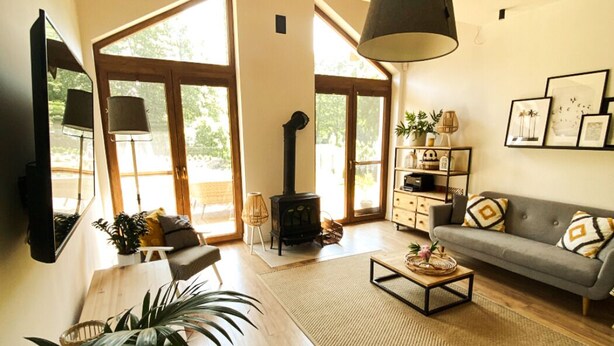Un salón amplio con un ventanal grande, una chimenea, un sofá y una mesita de centro.