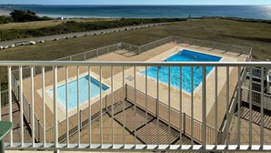 Un balcone con vista su una piscina e l'oceano.