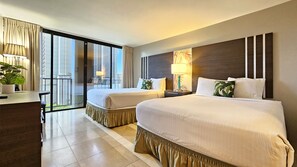 A hotel room with two beds, a desk, a chair, a lamp, and a view of the city through large windows. - Recently updated, Sleeps Four, Walk to Beach :) (Honolulu)