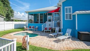 A blue house with a pool, patio furniture, and a white fence. - Treasure Beach House with private pool and dock (ST. AUGUSTINE)