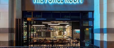 The exterior of The Ponce Room, featuring a modern bar area with seating and a well-lit entrance.