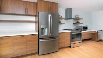 A modern kitchen with wooden cabinets, stainless steel appliances, and a microwave.