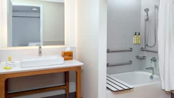 A bathroom with a white sink, mirror, and shower area.