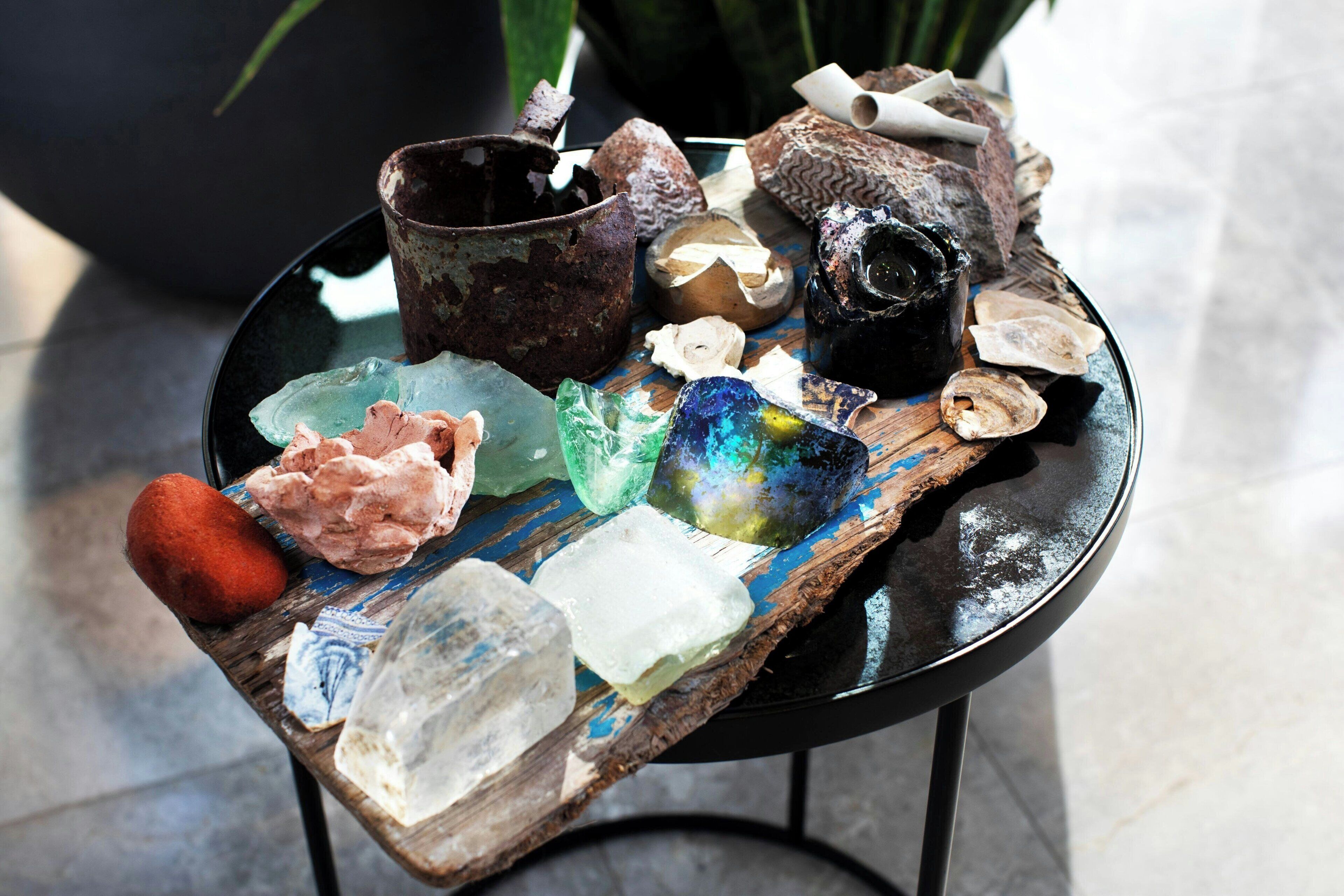 A table with various crystals and a rustic bowl.