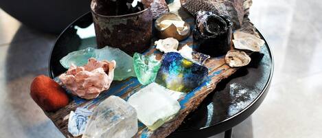 A table with various crystals and a rustic bowl.