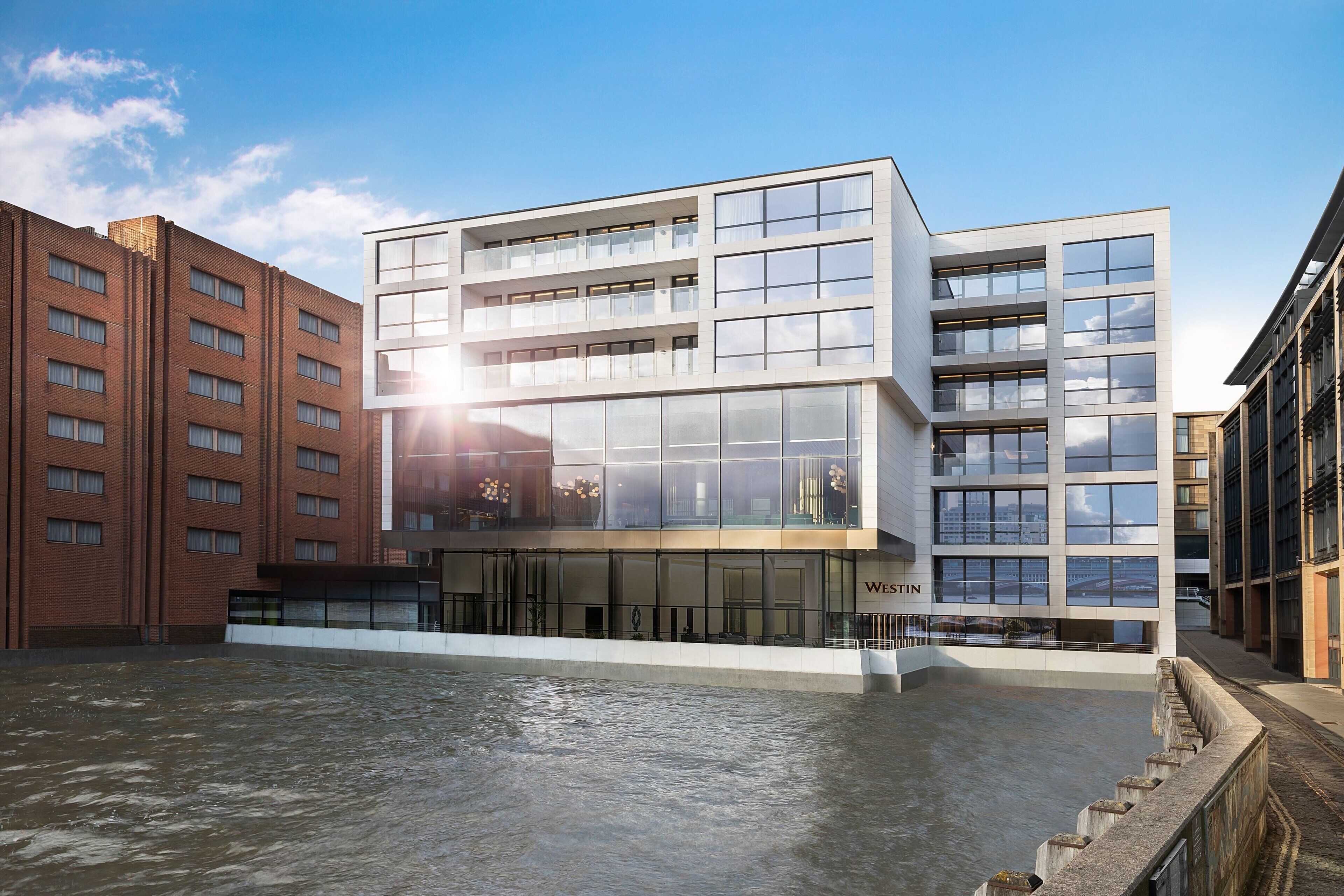 Un bâtiment moderne à plusieurs étages, doté de grandes fenêtres et d’une plaque signalétique portant l’inscription « WESTIN ».