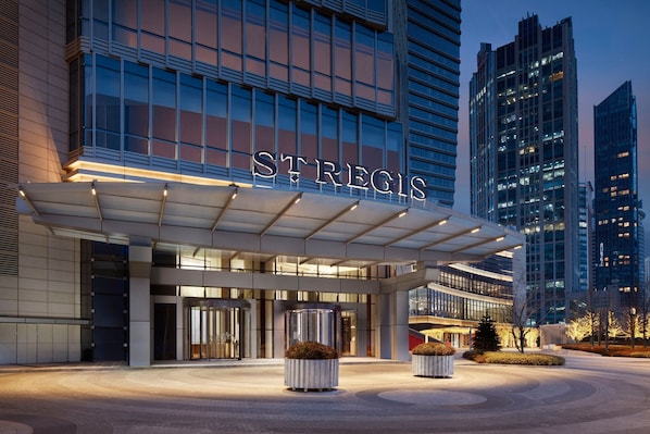 A modern hotel entrance with a prominent sign, large windows, and a well-lit facade. - The St. Regis Qingdao (Qingdao)
