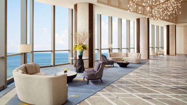 A spacious lobby with large windows, a chandelier, and a view of the ocean. - The St. Regis Qingdao (Qingdao)