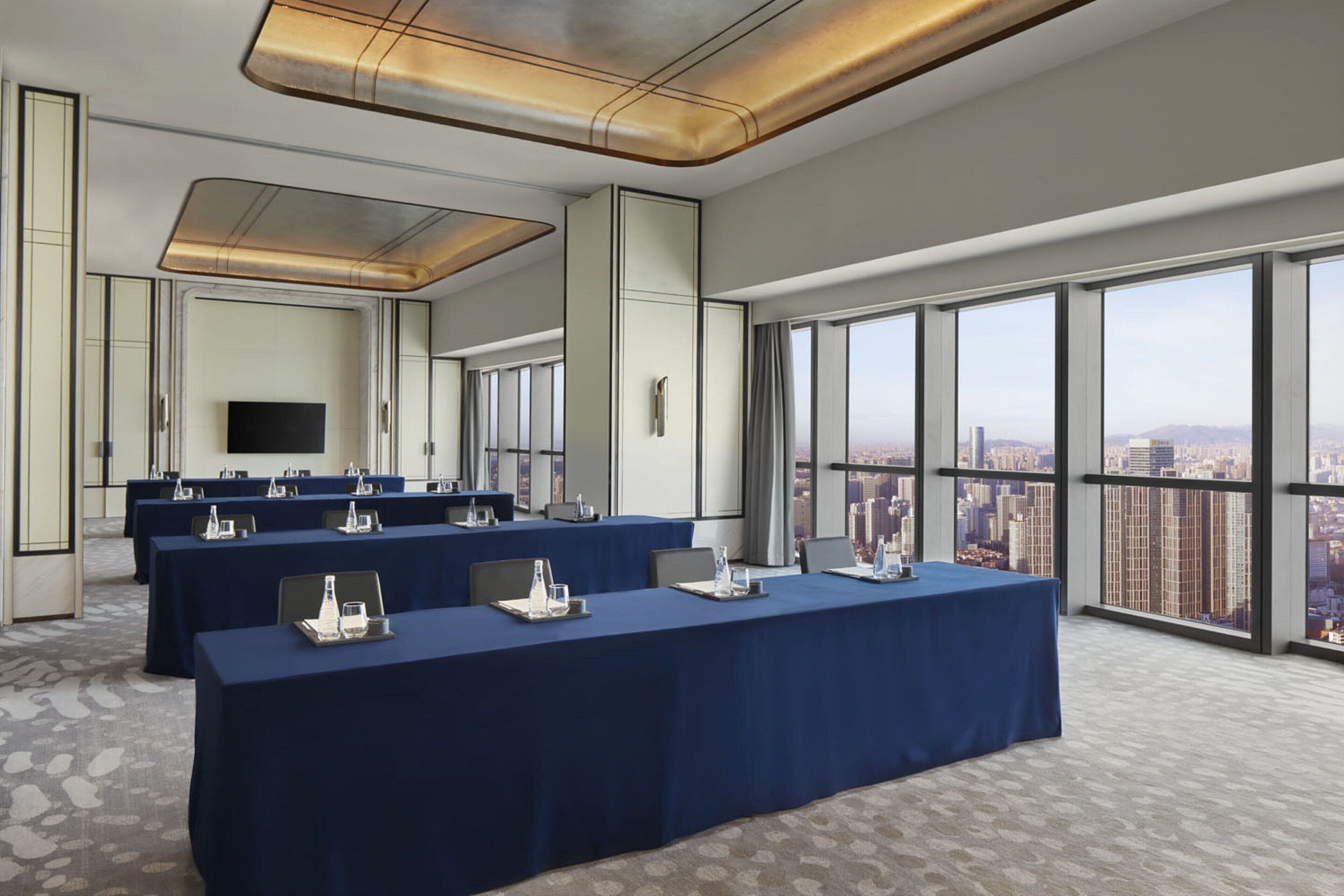 A conference room with a city view, large windows, and a modern ceiling design.