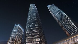 Three modern skyscrapers with illuminated windows against a night sky. - The St. Regis Qingdao (Qingdao)