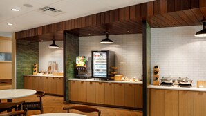 A modern kitchen with wooden cabinets, a white brick backsplash, and a refrigerator stocked with beverages. - Fairfield Inn & Suites by Marriott Knoxville Northwest (Knoxville)