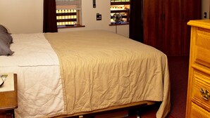 A bedroom with a bed, a dresser, a wardrobe, and a window with blinds. - Cozy, quirky and quaint updated Farm House surrounded by Sleeping Bear Dunes. (Maple City)
