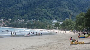 A beach with people, boats, and buildings in the background. - Facing the sea with a clear view of Patong Bay (Patong)