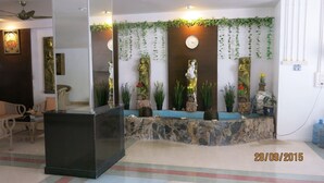 A reception area with a stone counter, decorative plants, and a clock on the wall. - Facing the sea with a clear view of Patong Bay (Patong)