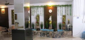 A reception area with a stone counter, decorative plants, and a clock on the wall. - Facing the sea with a clear view of Patong Bay (Patong)