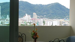 Un balcon avec vue sur la ville et les montagnes.