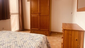 A bedroom with a bed, a wardrobe, and a dresser. - Spacious 3 bed/2 bath house, on a gated complex, Fibre Wifi. Two communal pools. (Antigua)