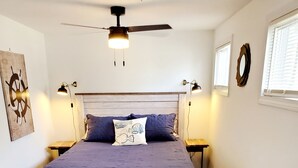 A bedroom with a bed, a ceiling fan, a rug, and a wall clock. - Steps to the Beach, Cozy Year Round Cottage 🐾 Pet Friendly (Old Saybrook)