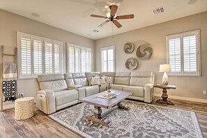 A spacious living room with a beige sectional sofa, a wooden coffee table, and a patterned rug. - Goodyear Home w/ Pool: Near Golf & Ballpark! (Goodyear)