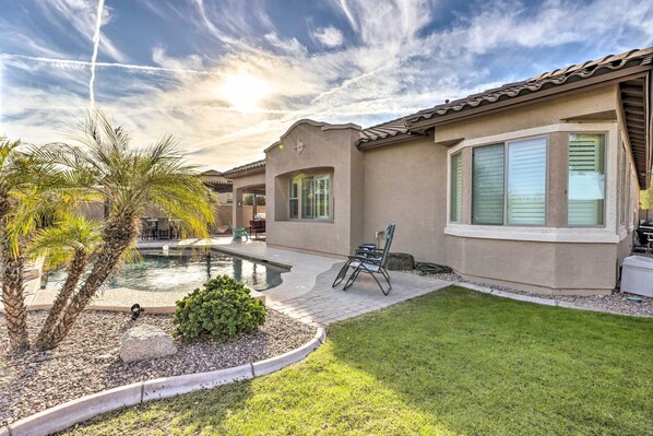 A residential property with a swimming pool, patio furniture, and a well-maintained lawn. - Goodyear Home w/ Pool: Near Golf & Ballpark! (Goodyear)
