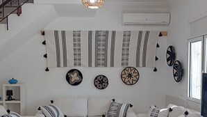 Un soggiorno moderno con un divano bianco, un tavolino da caffè e decorazioni a parete.