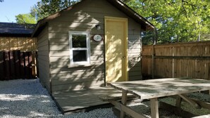 A small wooden shed with a door, a window, and a number '7' sign.