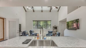 A modern kitchen with a central island, stainless steel sink, and ceiling fans. - Modern Alpine Cabin 3 Miles to Ski Cloudcroft (Cloudcroft)