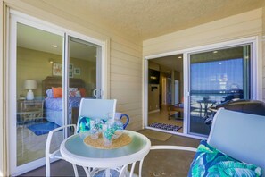 Relax in this open-plan living area with a sofa, round table, and balcony access.