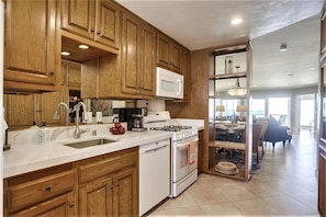 Enjoy cooking in this well-equipped kitchen with a large sink, microwave, stove, and dishwasher.