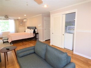 Quarto com cama, sofá, escrivaninha e guarda-roupa.
