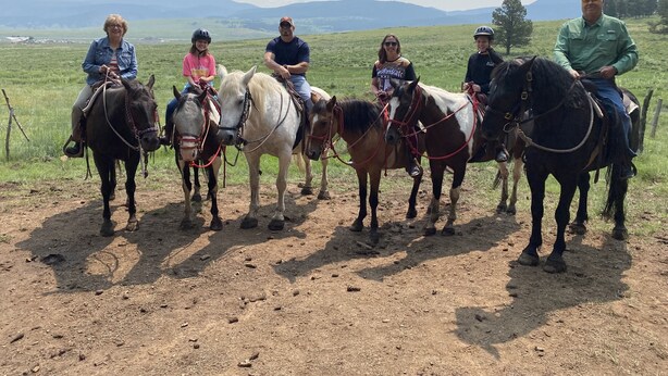 A group of people riding horses on a dirt path with a grassy field and mountains in the background. - 2BR Ground Floor Condo W/Easy Access to Chile Express!!!! (Angel Fire)