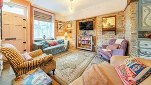 A cozy living room with a stone fireplace, comfortable seating, and a television. - Hebden Bridge - House - Sleeps 8 - Pet Friendly (Hebden Bridge)