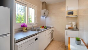 A modern kitchen with white cabinets, a stainless steel sink, a microwave, and a built-in oven. - Vacation home La Paz by Interhome (Calpe/Calp)