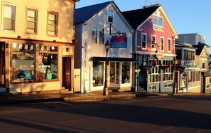 A row of colorful buildings with various storefronts, including a clothing store and a seafood restaurant.