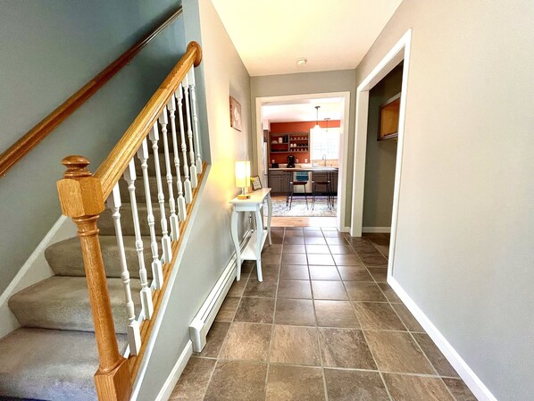 A staircase with wooden balusters leading to a landing with a white console table and a lamp.