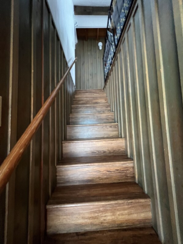 Una escalera de madera con barandilla que asciende.