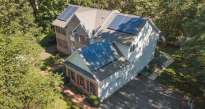 A two-story house with solar panels on the roof.