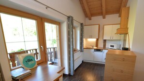 A compact kitchen with wooden cabinets, a microwave, and a sink. - Very attractive and well cared for apartment (Maria Alm)