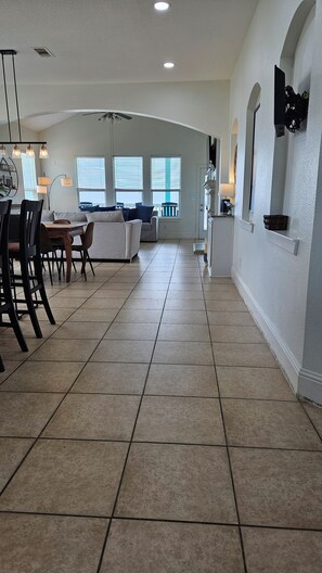 A spacious kitchen with a dining area, large windows, and a view of the backyard. - Beautiful Bayfront Retreat with Unbeatable Bay and Gulf Views (Bolivar Peninsula)