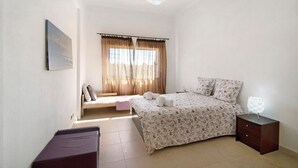 Una camera da letto con un letto, un comodino e una finestra con tende.