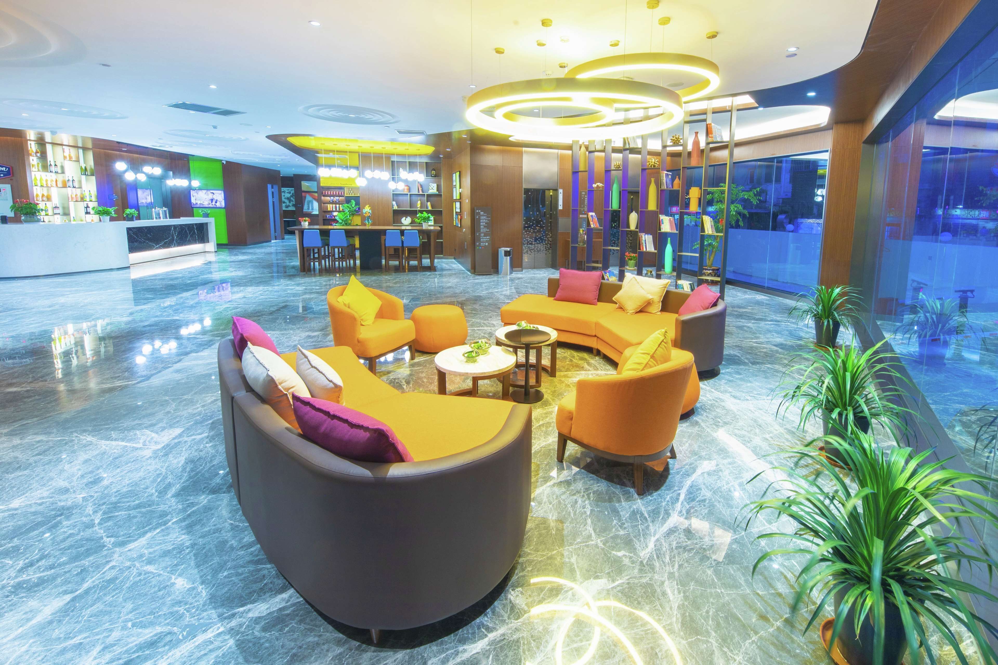 A modern lobby with a curved seating area, a bar, and a large window overlooking the interior.