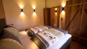 Una camera da letto con un letto, due comodini, un armadio e luci a parete.