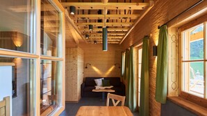 Un intérieur en bois avec une table en bois, un canapé et des rideaux.