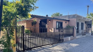 A residential property with a gated entrance, a paved driveway, and a house with a tiled roof. - Cozy and comfy little house in the heart of Loreto (Loreto)