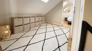 A bedroom with a skylight, a bed, a dresser, and a wardrobe. - Villa Alexandra (Le Crotoy)