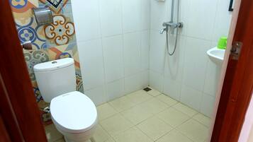 Ein kleines Badezimmer mit Toilette, Dusche und Waschbecken.